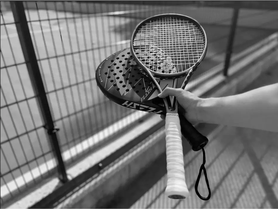 Close-up comparison of a tennis racket and a padel racket, highlighting the differences in size and design.