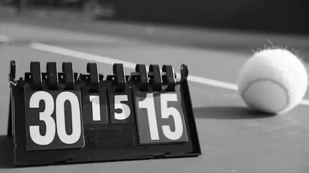 A black and white image of a tennis score counter showing 30-15, with a tennis ball on the court in the background.