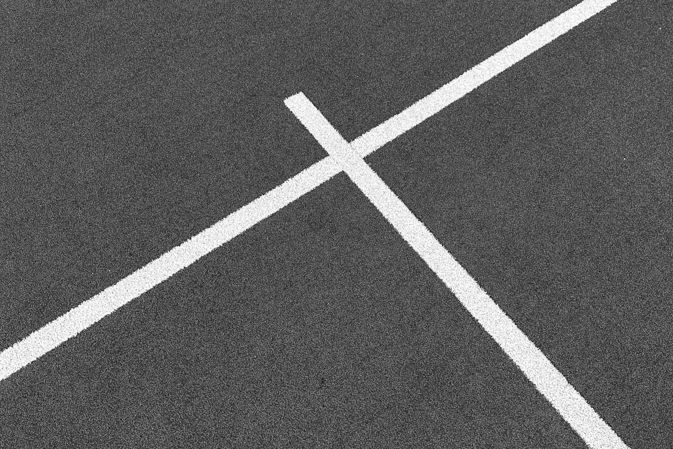 Close-up of clean, white padel court lines on a well-maintained artificial turf surface.